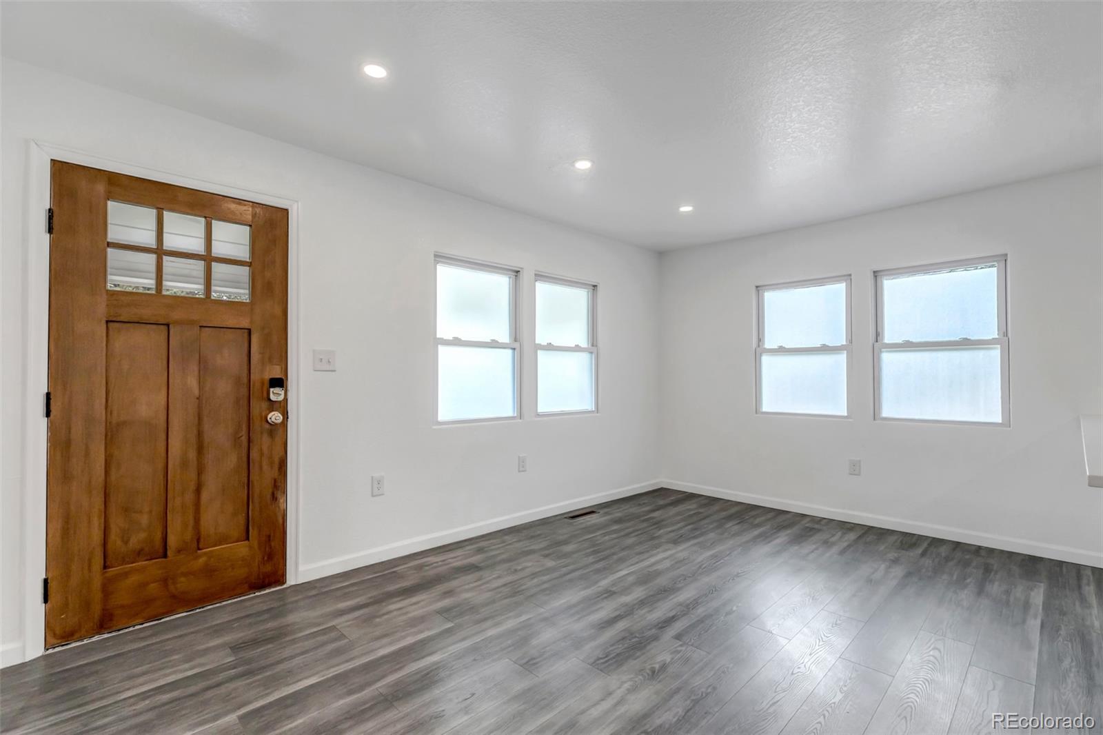 10 South Irving Street Denver, CO 80219 - Photo 8 of 35 an empty room with wooden floor and windows