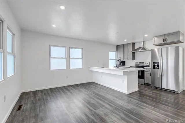 a kitchen with a refrigerator and white cabinets