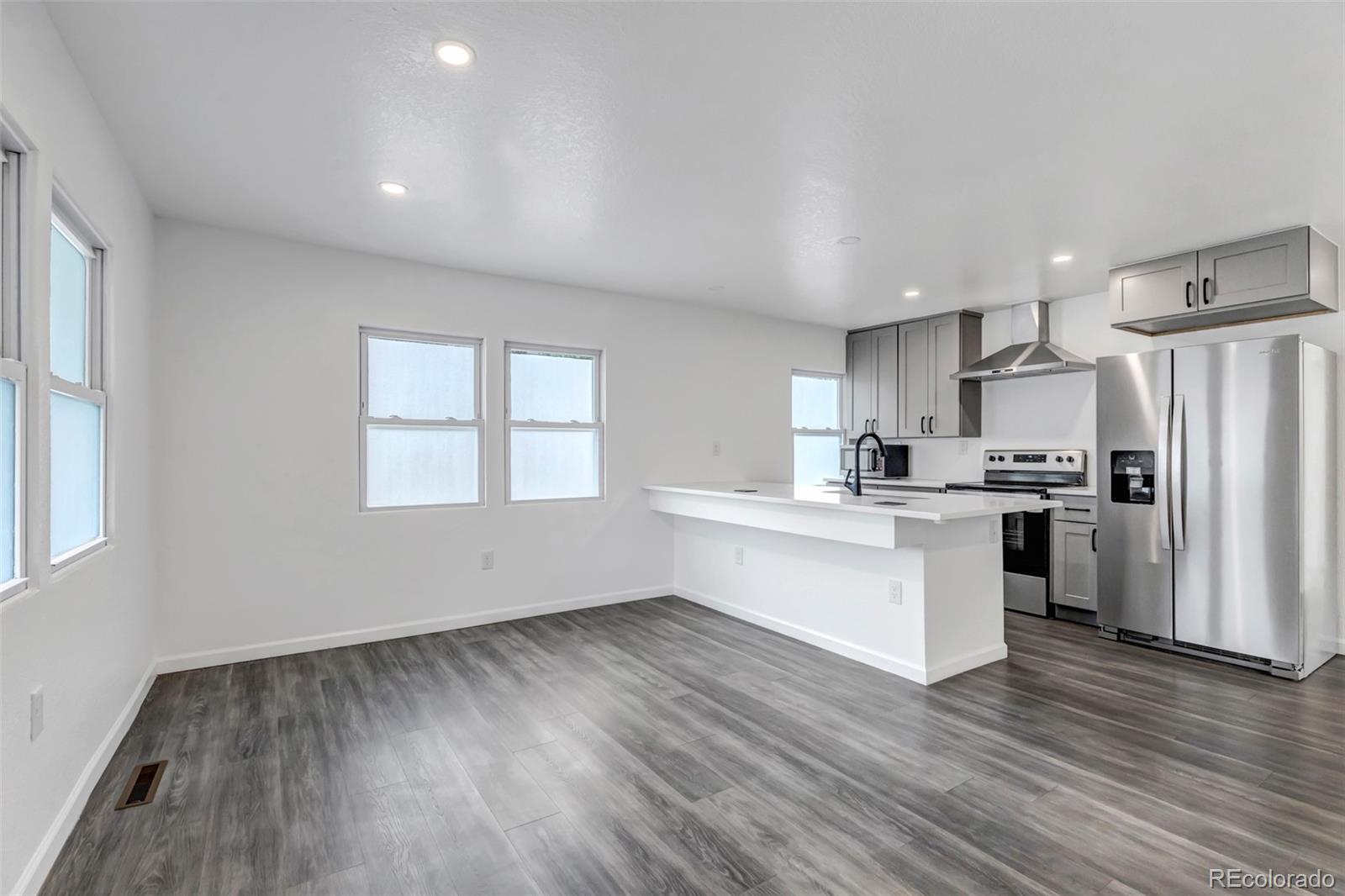 10 South Irving Street Denver, CO 80219 - Photo 9 of 35 a kitchen with a refrigerator and white cabinets