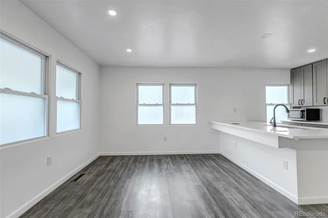 a view of a kitchen with wooden floor and electronic appliances