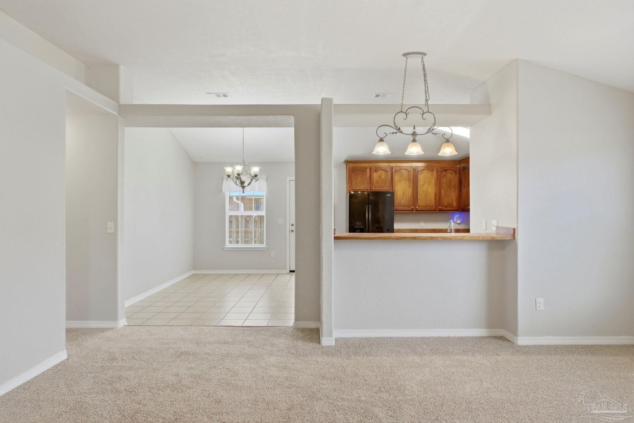8100 Castle Pointe Way Pensacola, FL 32506 - Photo 11 of 44 an empty room that has a dining table and chandelier
