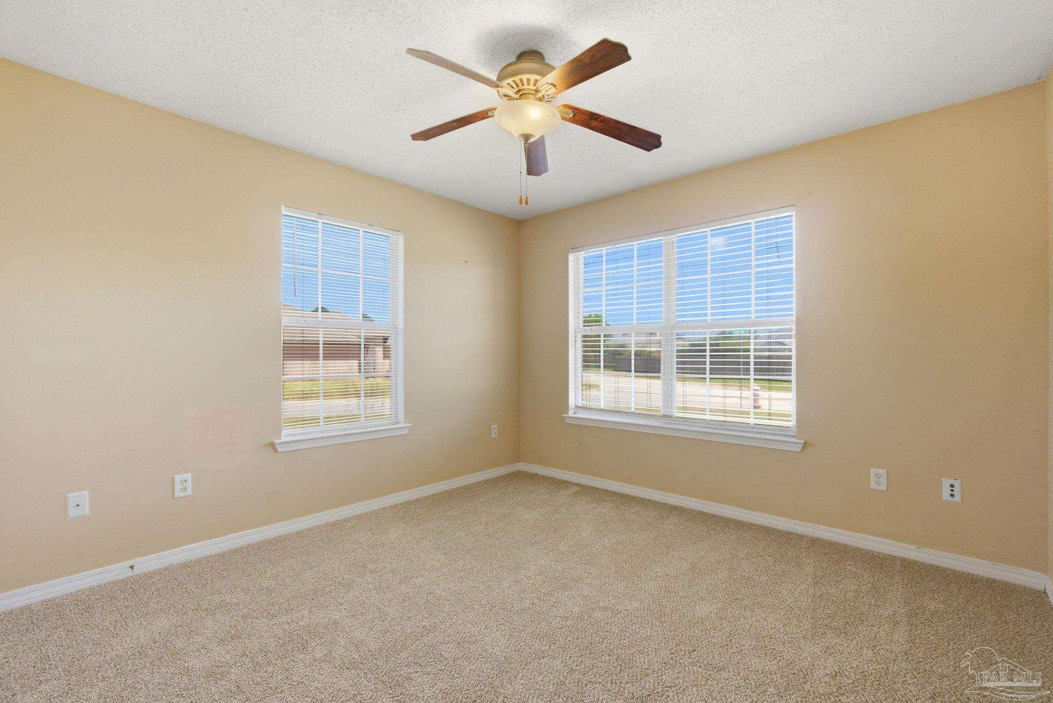8100 Castle Pointe Way Pensacola, FL 32506 - Photo 33 of 44 an empty room with a window and a ceiling fan