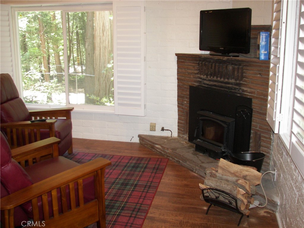 1101 Big Tree Lane Crestline, CA 92325 - Photo 14 of 30 a living room with furniture a flat screen tv and a fireplace