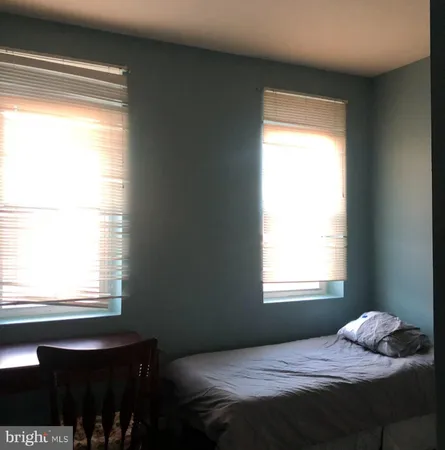 a bedroom with a bed window and a table