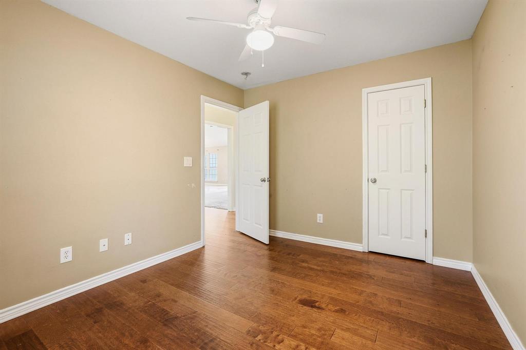 386 Scoggins Road Tioga, TX 76271 - Photo 17 of 30 an empty room with wooden floor and door