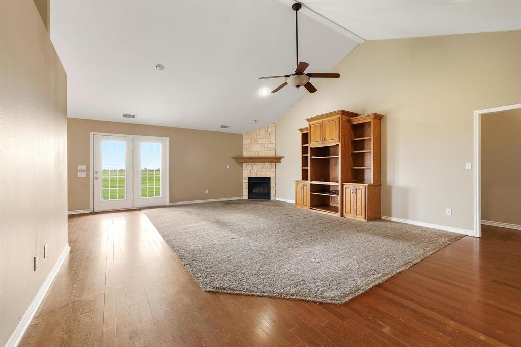 386 Scoggins Road Tioga, TX 76271 - Photo 10 of 30 a view of empty room with a fireplace and wooden floor