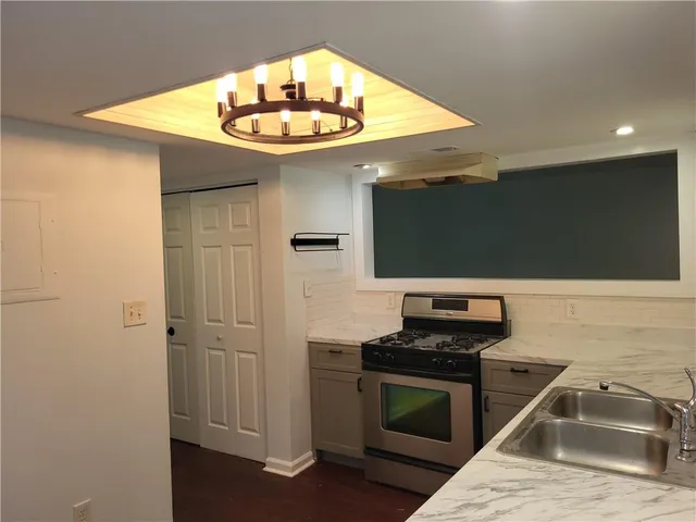 a kitchen with stainless steel appliances granite countertop a sink and a stove