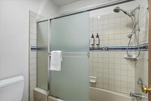 a bathroom with a granite countertop sink mirror vanity and toilet