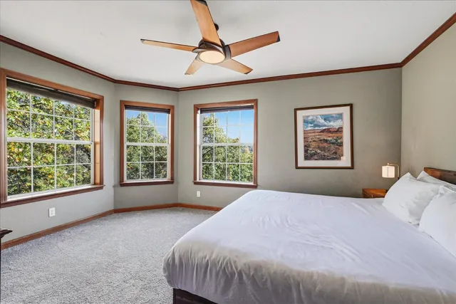a bedroom with a bed a chandelier and a large window