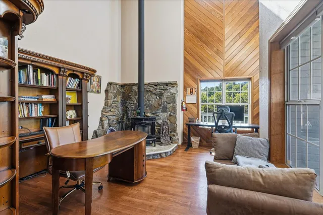 a living room with furniture wooden floor and kitchen view