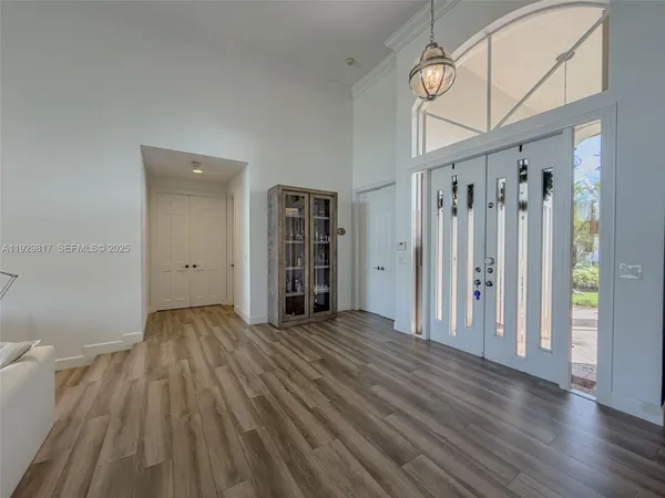 a living room with furniture floor to ceiling window and hardwood floor