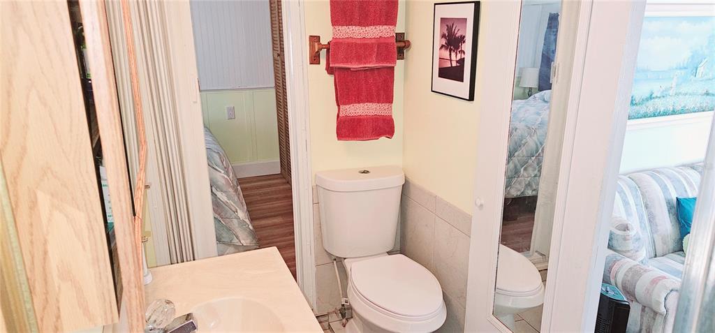 10315 Cortez Road West, Unit 714 Bradenton, FL 34210 - Photo 11 of 26 a white toilet sitting next to a bathroom sink and a mirror