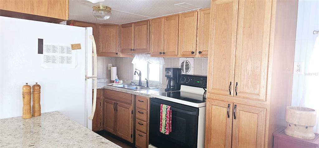 10315 Cortez Road West, Unit 714 Bradenton, FL 34210 - Photo 14 of 26 a kitchen with stainless steel appliances granite countertop a sink and a refrigerator