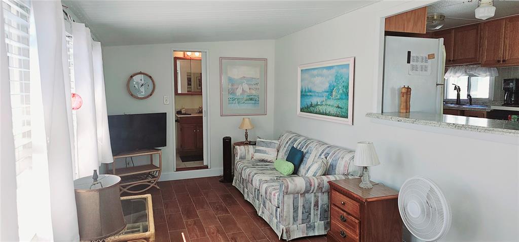 10315 Cortez Road West, Unit 714 Bradenton, FL 34210 - Photo 4 of 26 a living room with furniture a flat screen tv and a fireplace