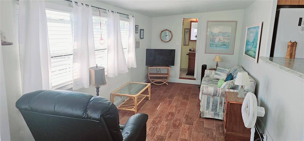10315 Cortez Road West, Unit 714 Bradenton, FL 34210 - Photo 6 of 26 a living room with furniture a flat screen tv and a large window