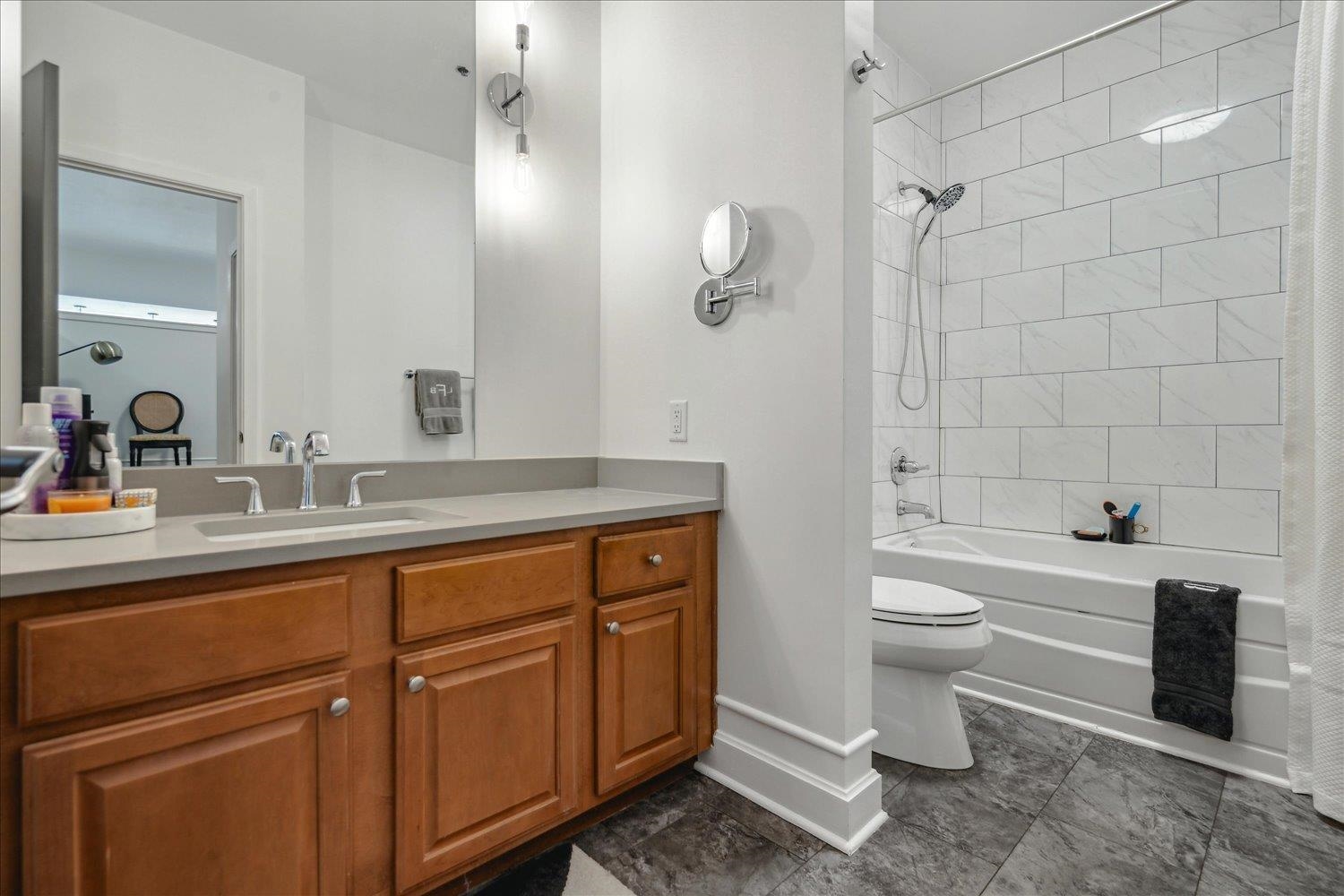 648 Riverside Drive, Unit 411 Memphis, TN 38103 - Photo 15 of 32 a bathroom with a toilet a sink a mirror a bathtub and vanity