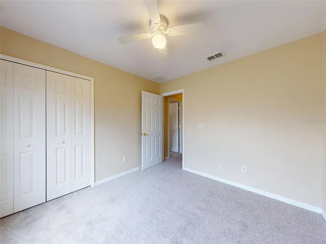 a view of an empty room and a ceiling fan window