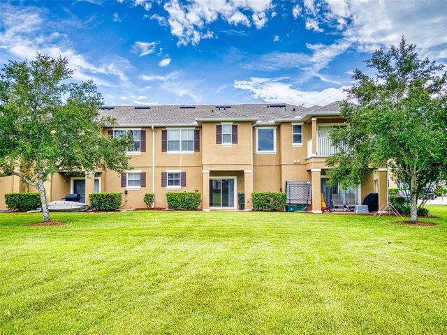 a view of a house with a big yard and large trees