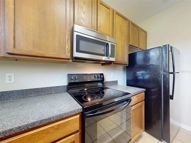 a kitchen with stainless steel appliances granite countertop a stove a microwave and a refrigerator