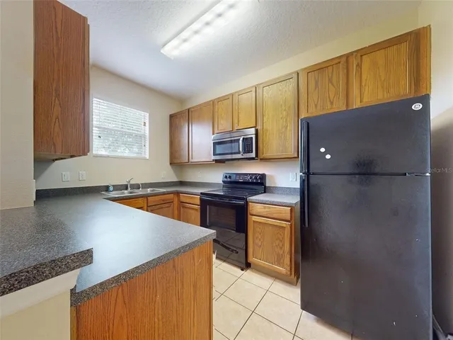 a kitchen with stainless steel appliances granite countertop a refrigerator a stove top oven a sink and dishwasher