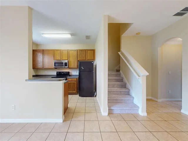 a kitchen with granite countertop a refrigerator a stove and cabinets