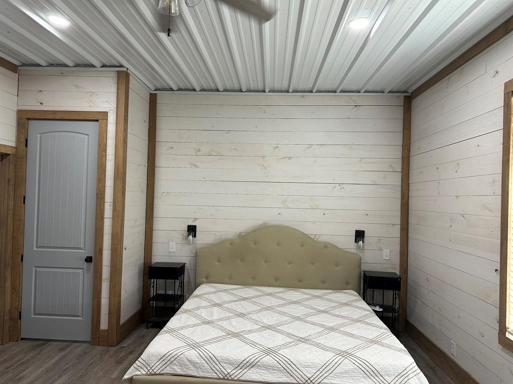 511 John Davis Road Italy, TX 76651 - Photo 31 of 40 a bedroom with a bed and a wooden floor