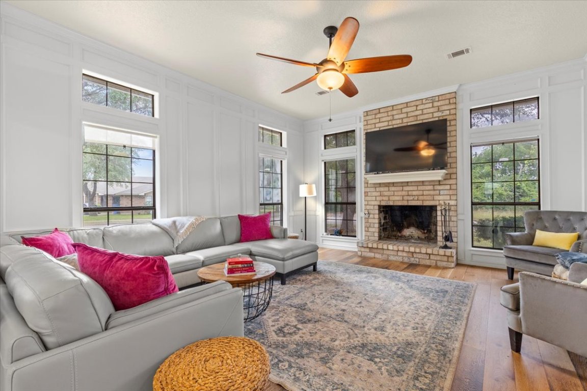 a living room with furniture a flat screen tv and a fireplace