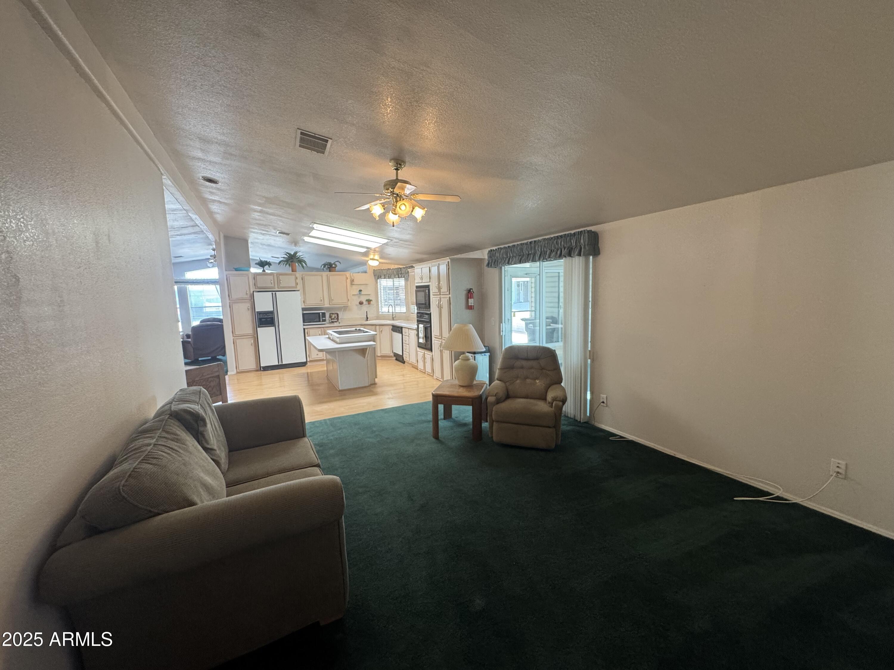 215 North Power Road, Unit 199 Mesa, AZ 85205 - Photo 18 of 27 a living room with furniture and a chandelier