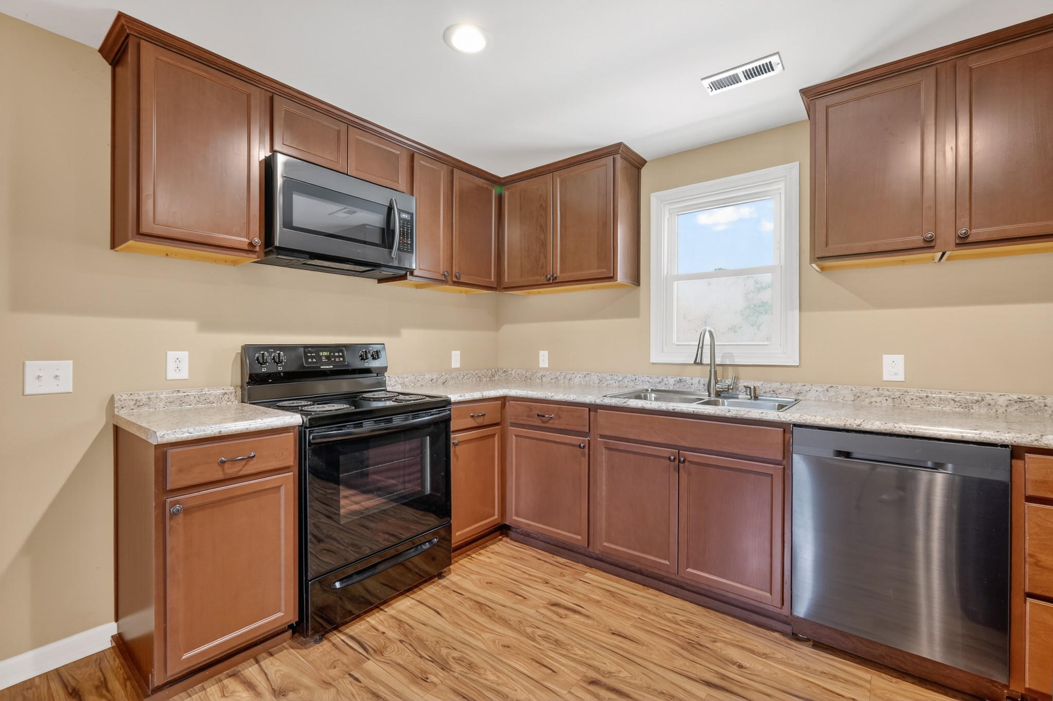 11914 Hogwood Road Milton, TN 37118 - Photo 18 of 44 a kitchen with granite countertop wooden cabinets stainless steel appliances and a sink
