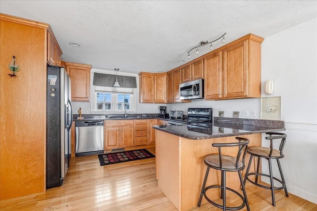 4 Old Field Road Plymouth, MA 02360 - Photo 12 of 42 a kitchen with stainless steel appliances granite countertop a stove top oven a sink dishwasher and a refrigerator with wooden floor