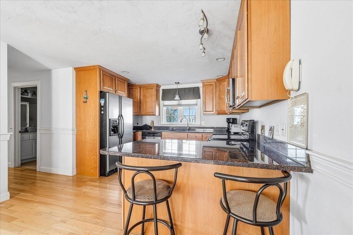 4 Old Field Road Plymouth, MA 02360 - Photo 14 of 42 a kitchen with stainless steel appliances granite countertop a refrigerator a sink a stove and island with wooden floor