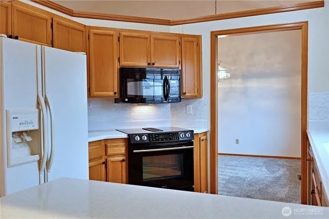 a kitchen with stainless steel appliances granite countertop a refrigerator a stove and a sink