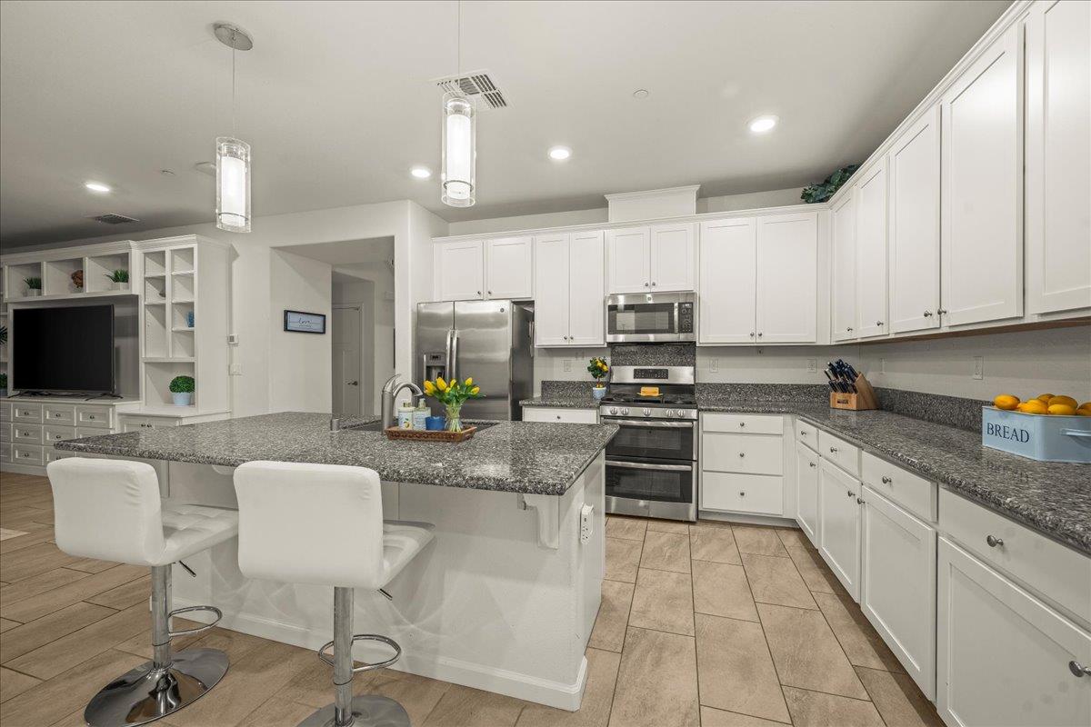 12791 Evanston Way Rancho Cordova, CA 95742 - Photo 39 of 54 a kitchen with stainless steel appliances kitchen island granite countertop a sink and cabinets