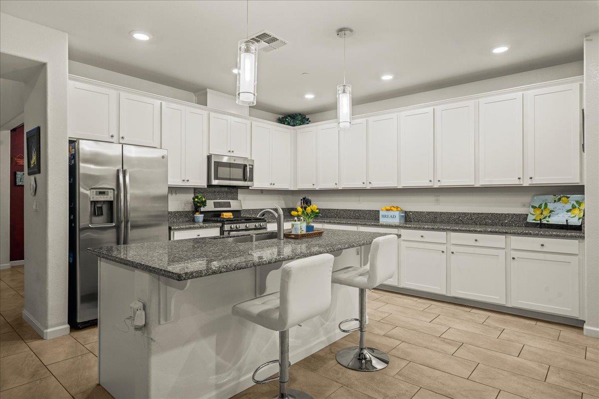 12791 Evanston Way Rancho Cordova, CA 95742 - Photo 40 of 54 a kitchen with stainless steel appliances granite countertop a refrigerator oven a sink a stove a dining table and chairs