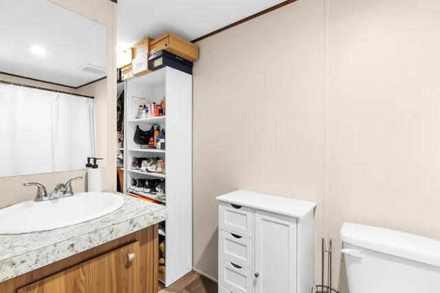 a bathroom with a granite countertop sink a toilet and shower