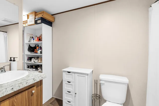 a bathroom with a granite countertop sink and a toilet