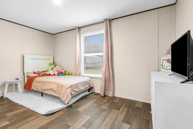 a bedroom with a bed and a flat screen tv