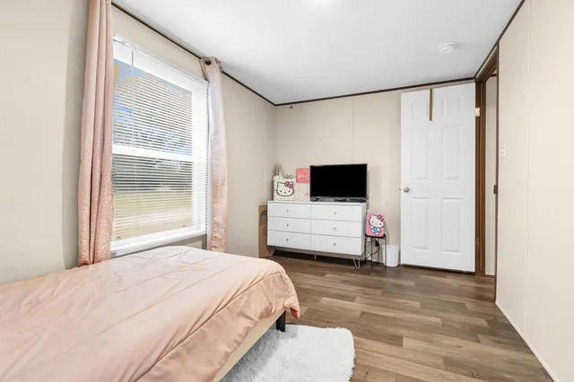 a room with a bed window and a flat screen tv