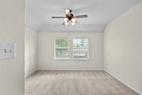 an empty room with a window and a fan