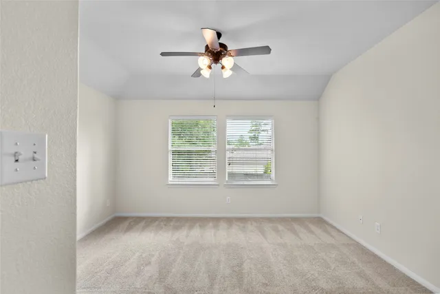 an empty room with a window and a fan