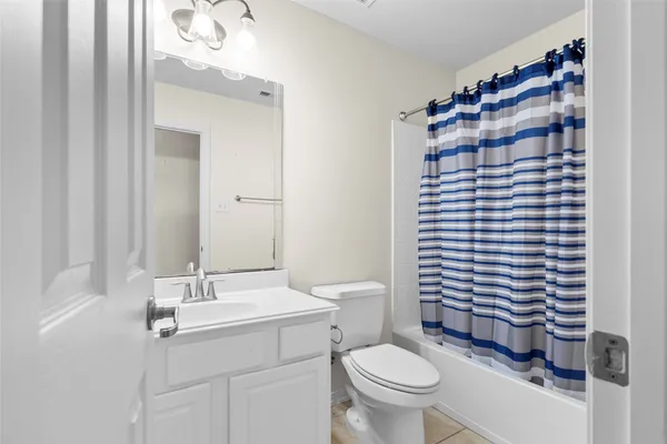 a bathroom with a sink a toilet and shower curtain