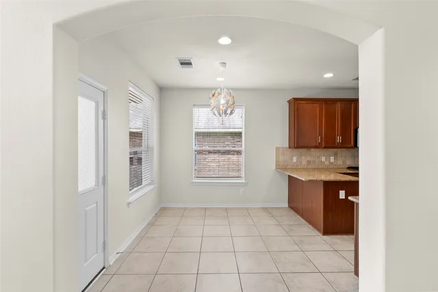 a room with granite countertop a sink a stove and cabinets