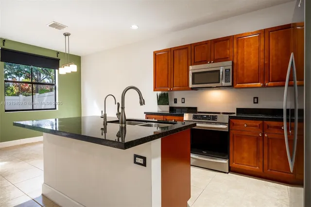 a kitchen with stainless steel appliances granite countertop a stove a sink dishwasher a microwave oven with granite countertops and cabinets