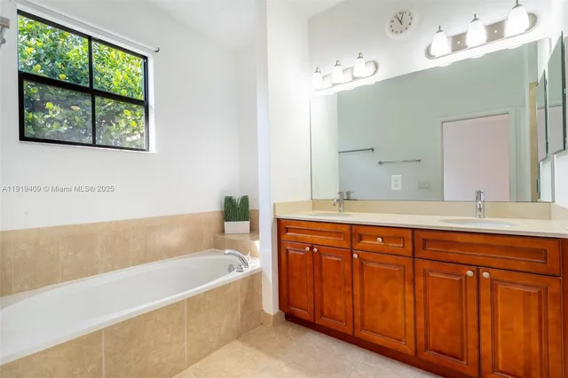 a spacious bathroom with a tub sink and mirror