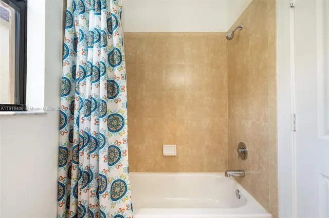 a bathroom with a bathtub and shower curtain