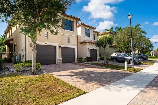 a view of a white house with a patio and a yard