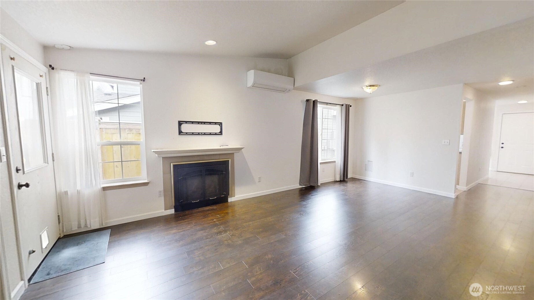 6039 Merlot Lane Southeast Lacey, WA 98513 - Photo 7 of 21 an empty room with wooden floor fireplace and windows