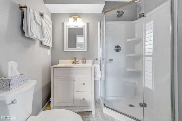 a bathroom with a granite countertop sink toilet and shower