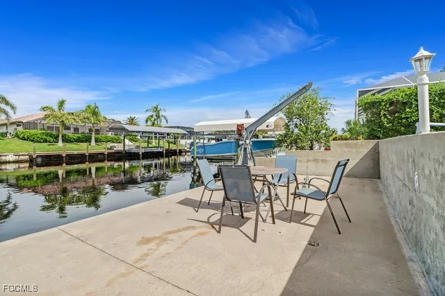 a view of a patio with dining table and chairs with wooden fence