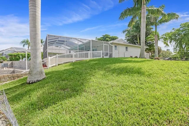 a view of a house with a yard and a palm tree